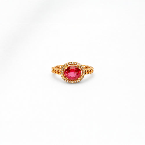 Gold ring with a red gemstone on a white background